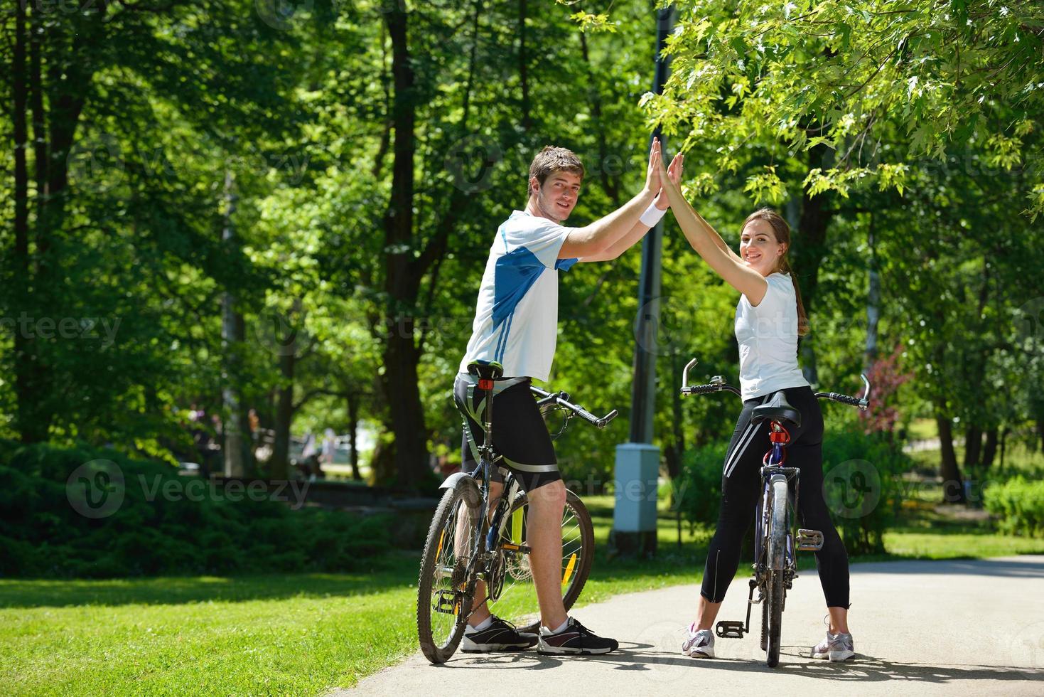 Happy couple riding bicycle outdoors photo