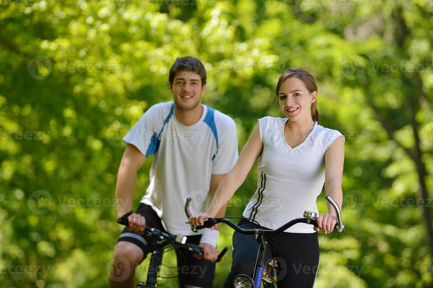 Happy couple riding bicycle outdoors photo