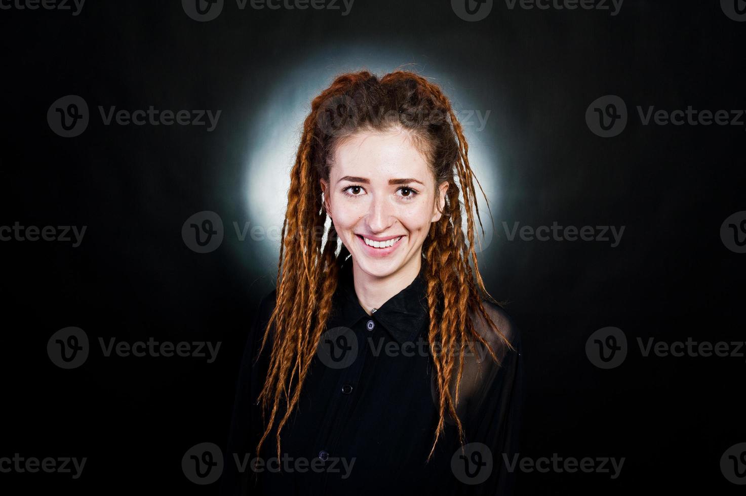 Studio shoot of girl in black with dreads at black background with nimbus. photo