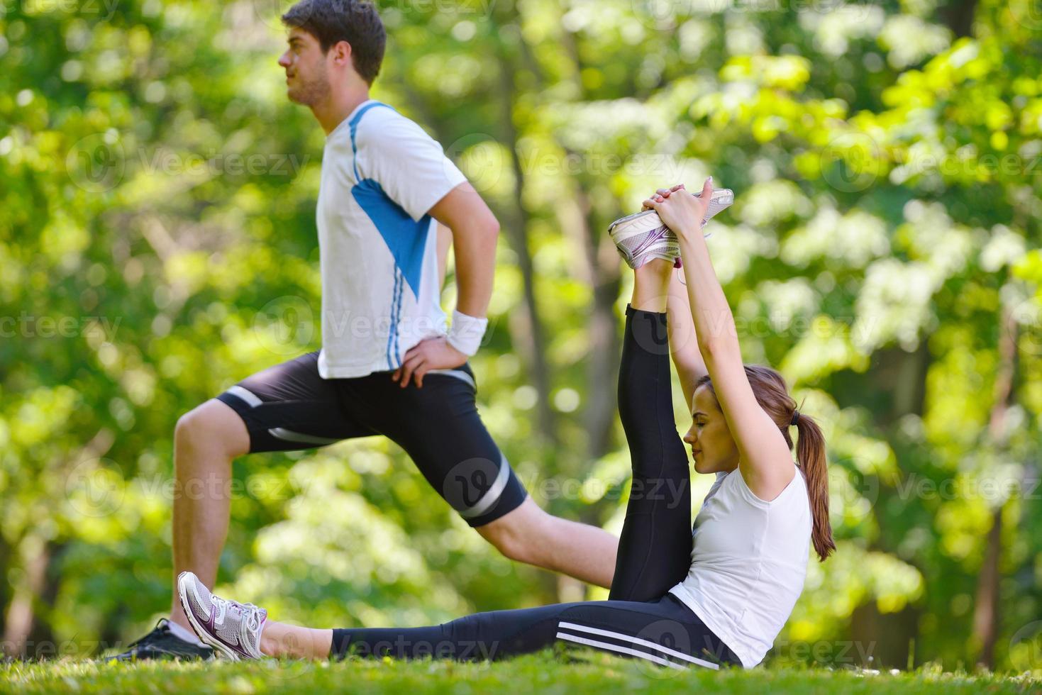 Couple doing stretching exercise  after jogging photo