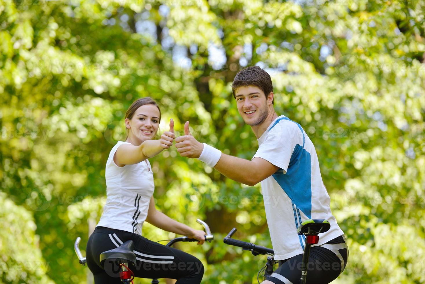 Happy couple riding bicycle outdoors photo