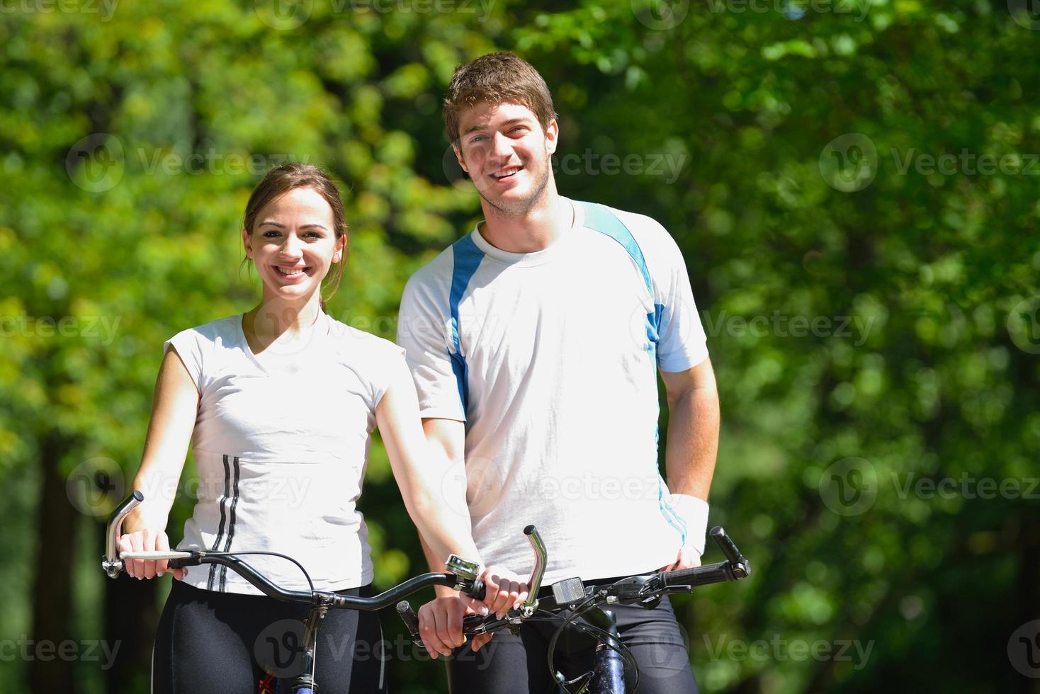 Happy couple riding bicycle outdoors photo