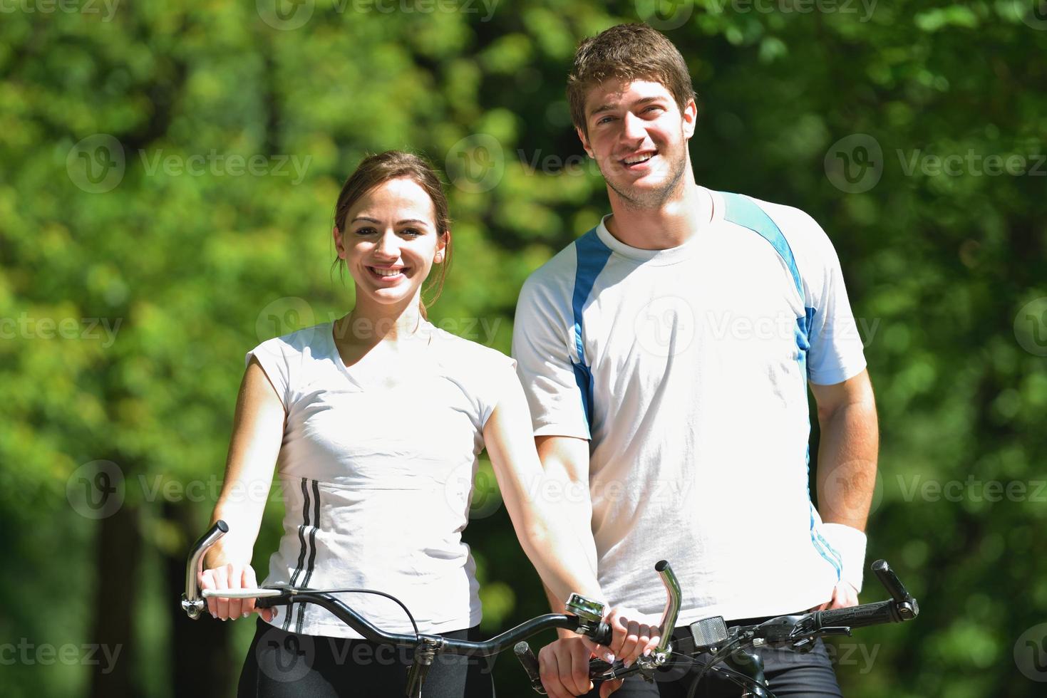 Happy couple riding bicycle outdoors photo