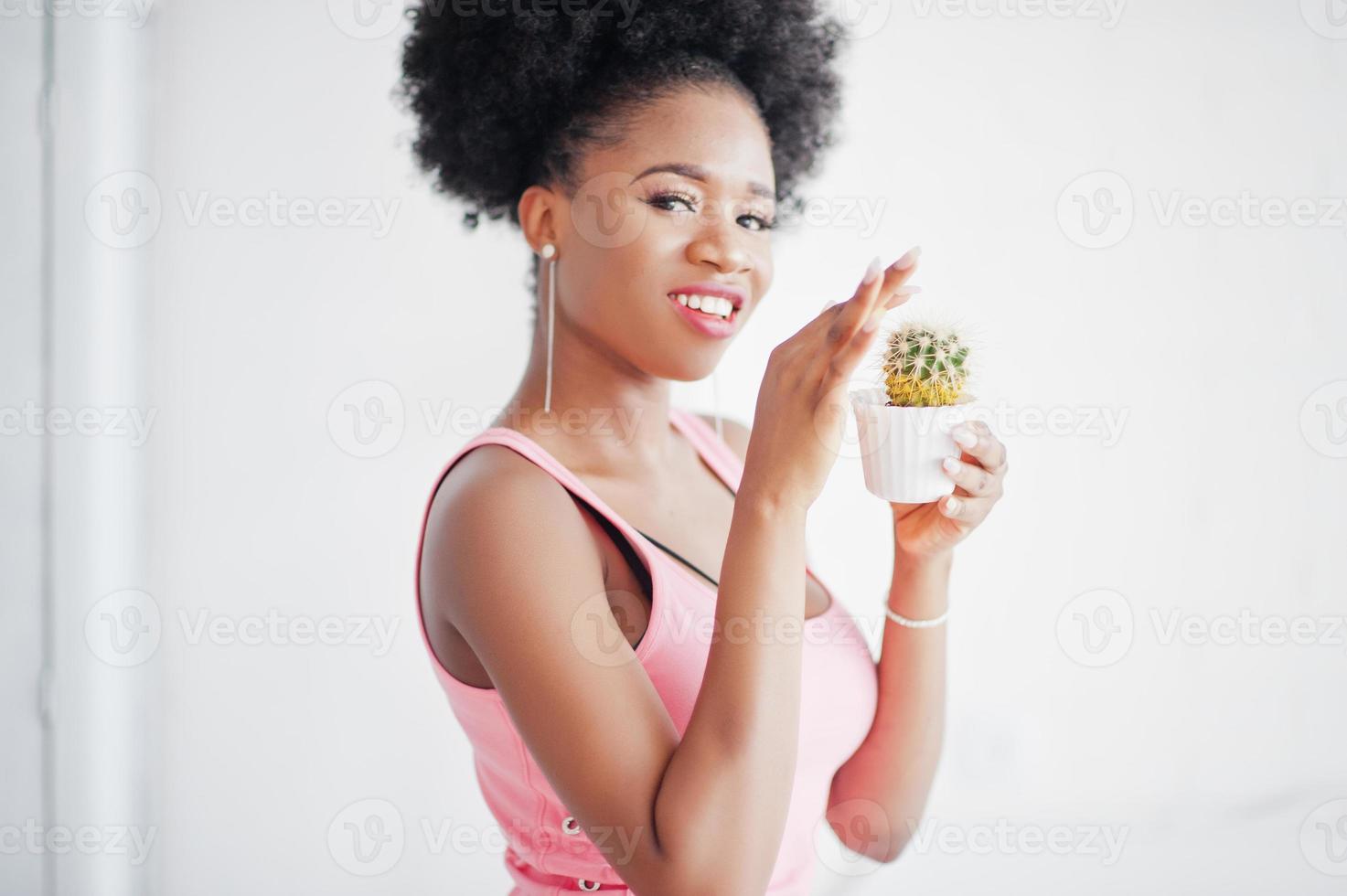 Young african american woman in pink singlet with cactus at hands. photo