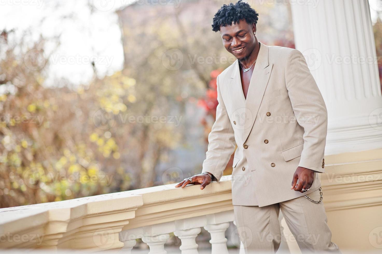 Stylish afro man in beige old school suit. Fashionable young African male in casual jacket on bare torso. photo