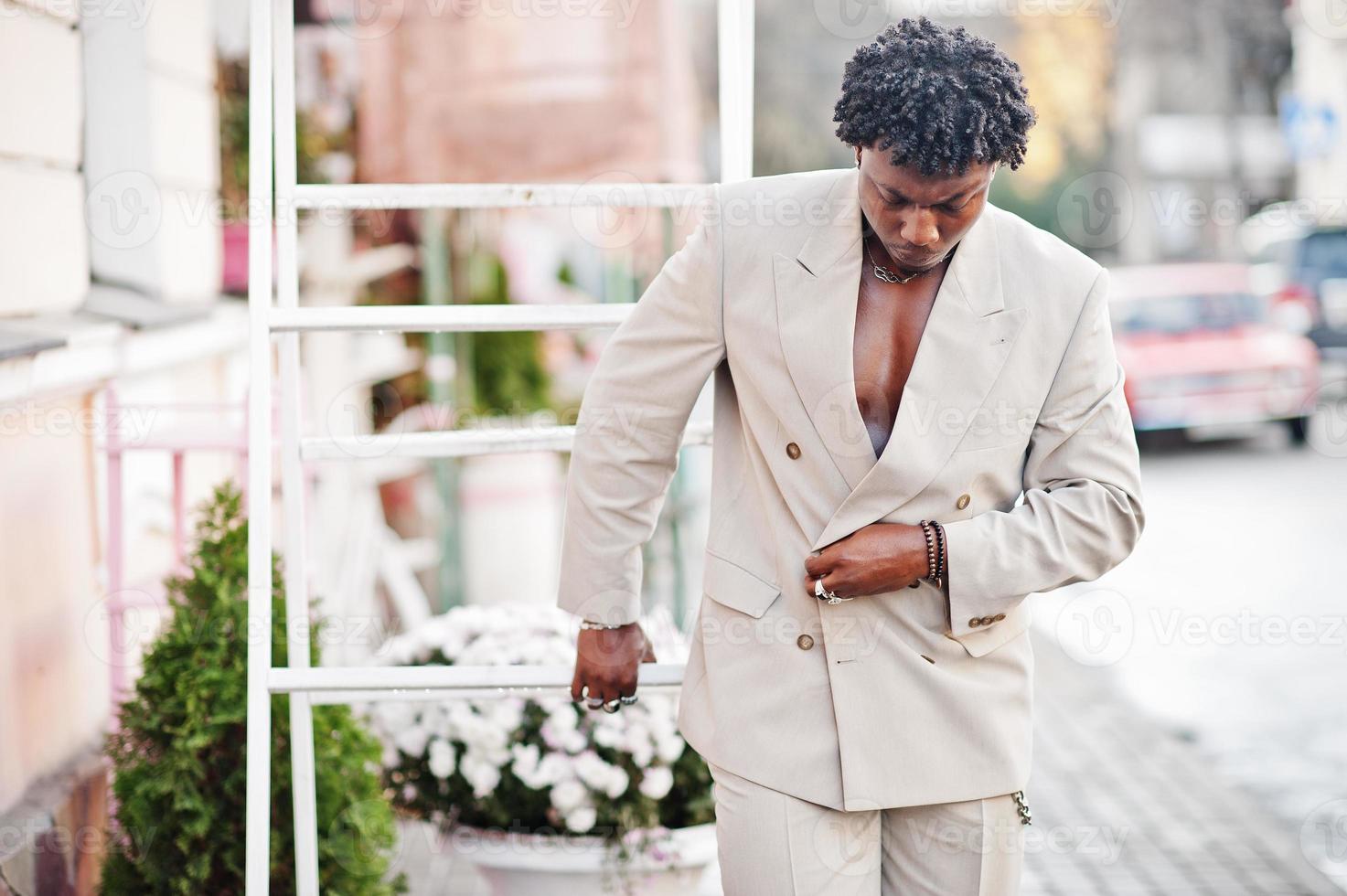 Stylish afro man in beige old school suit. Fashionable young African male in casual jacket on bare torso. photo