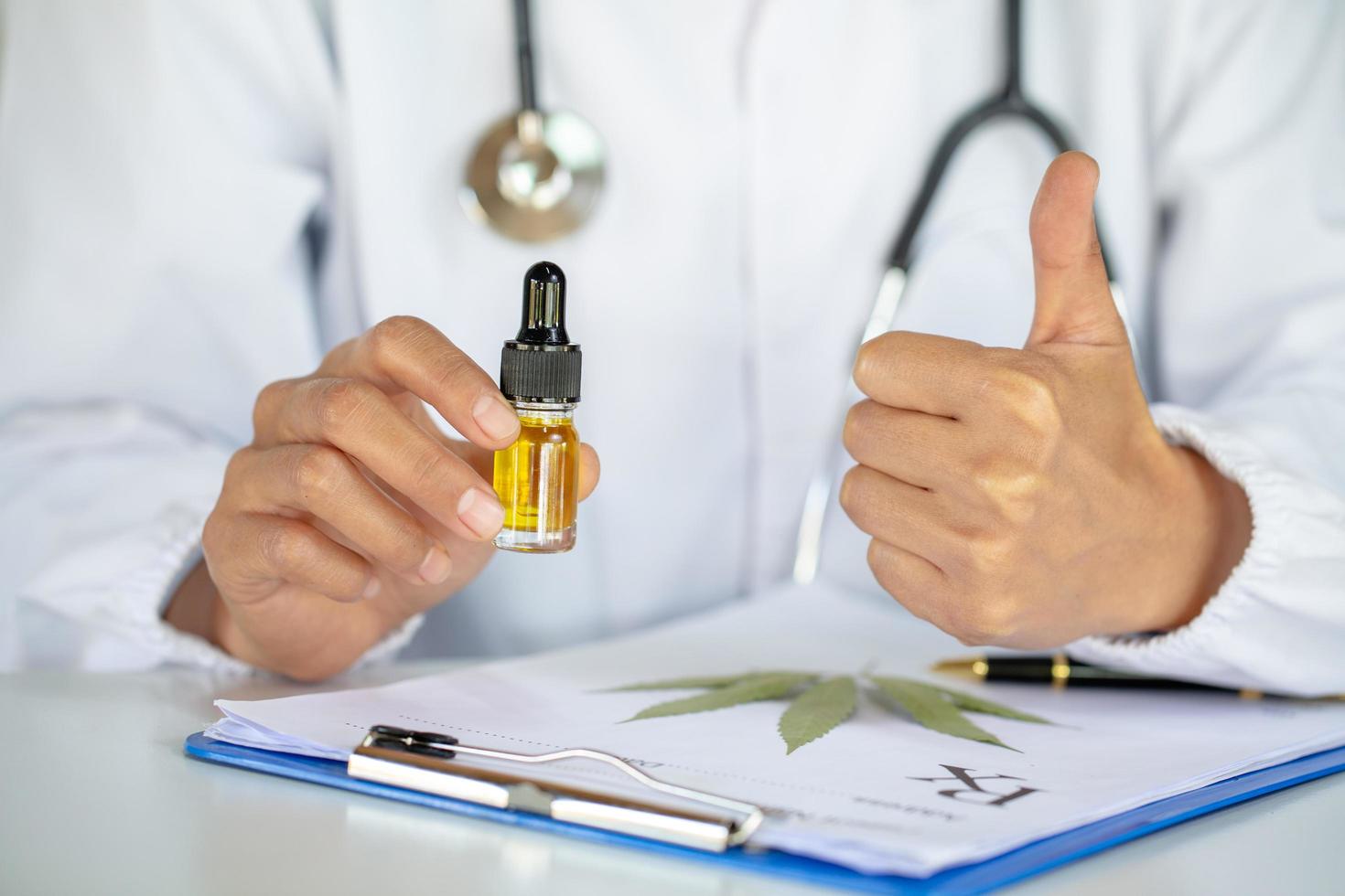 Doctors  holding bottle of Cannabis oil in pipette,hemp product, CBD cannabis OIL.  medical marijuana concept. photo