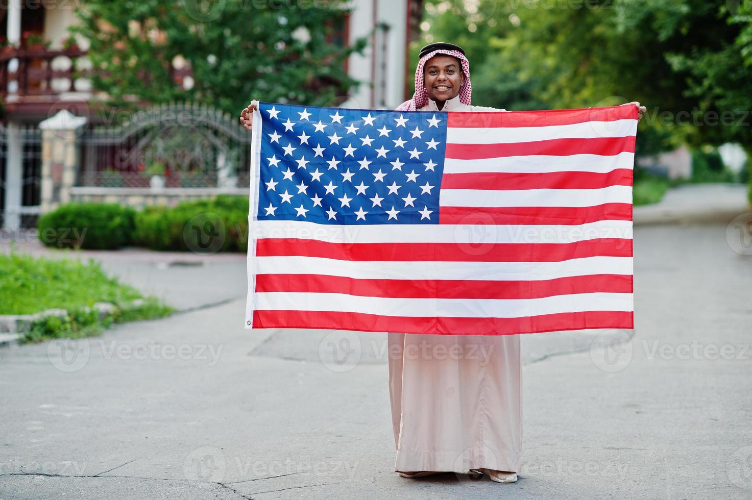 hombre árabe del medio oriente posó en la calle con la bandera de estados unidos. concepto de américa y los países árabes. foto