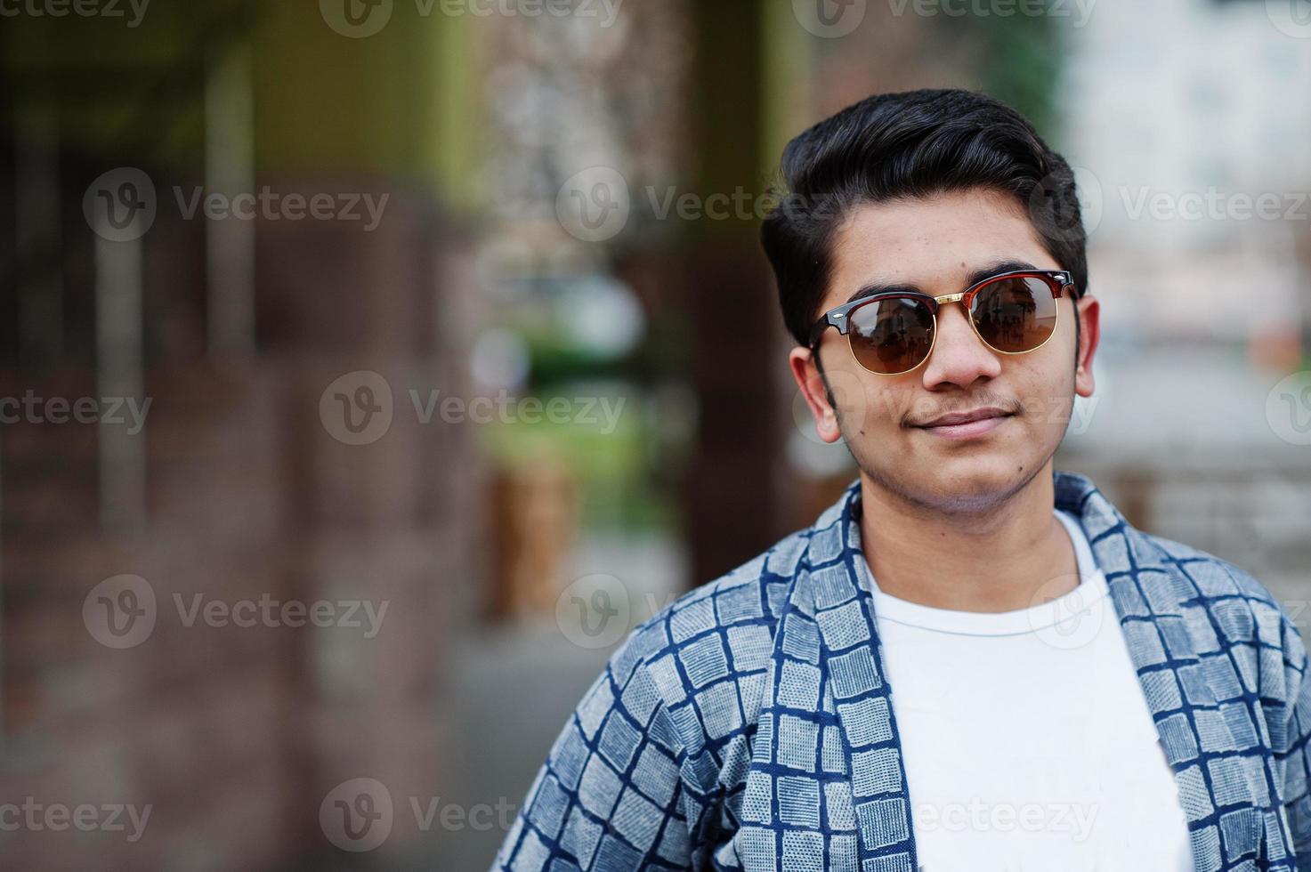 Stylish indian young man at sunglasses wear casual posed outdoor. photo