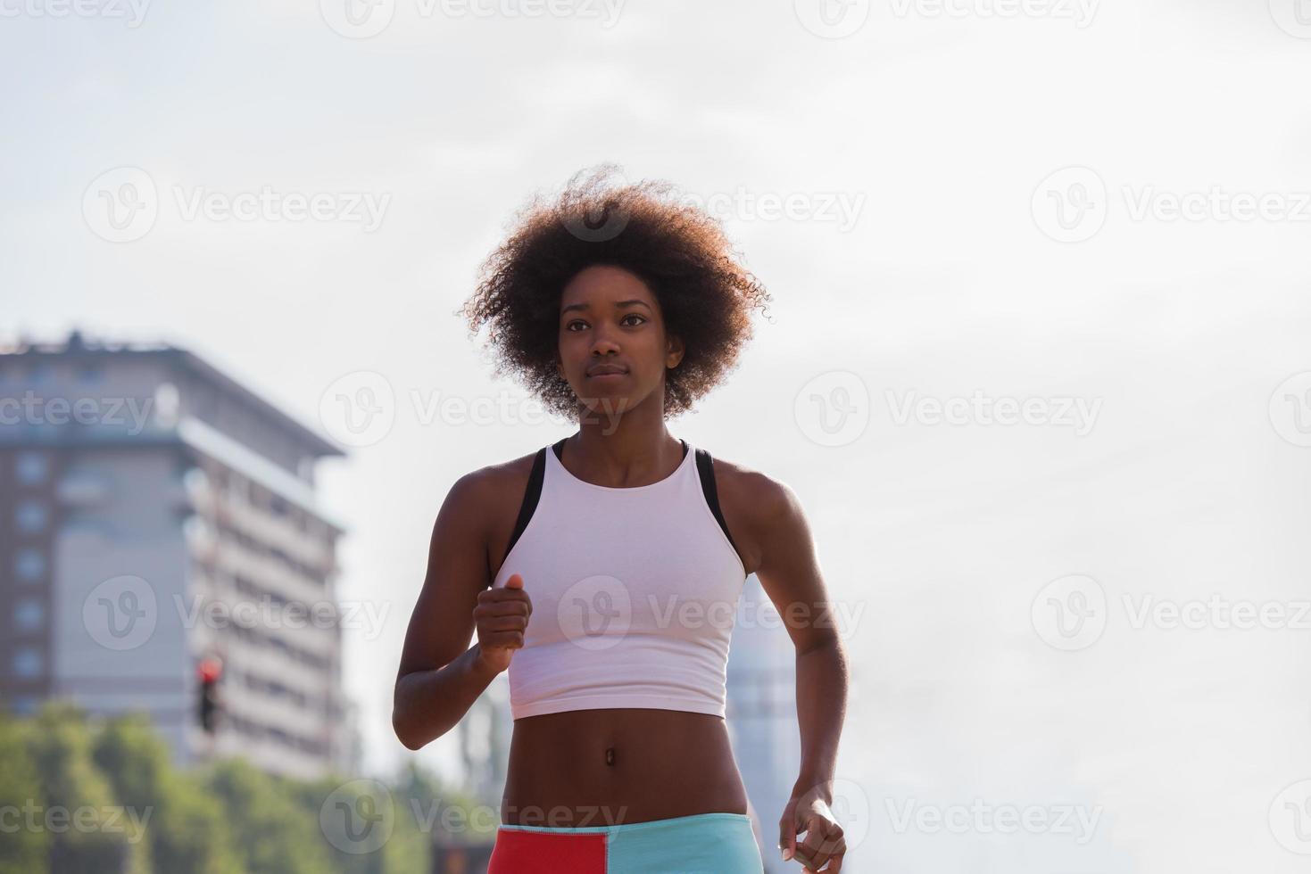 Portrait of sporty young african american woman running outdoors photo