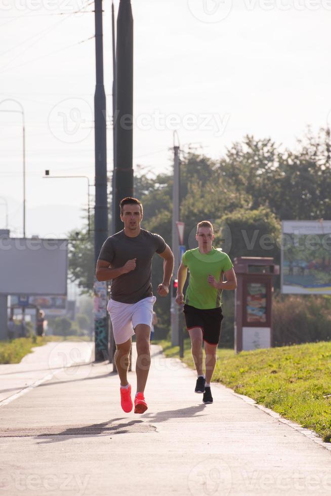 Two young men jogging through the city photo