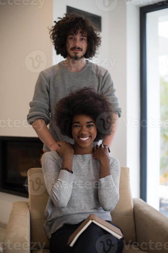 multiethnic couple hugging in front of fireplace photo