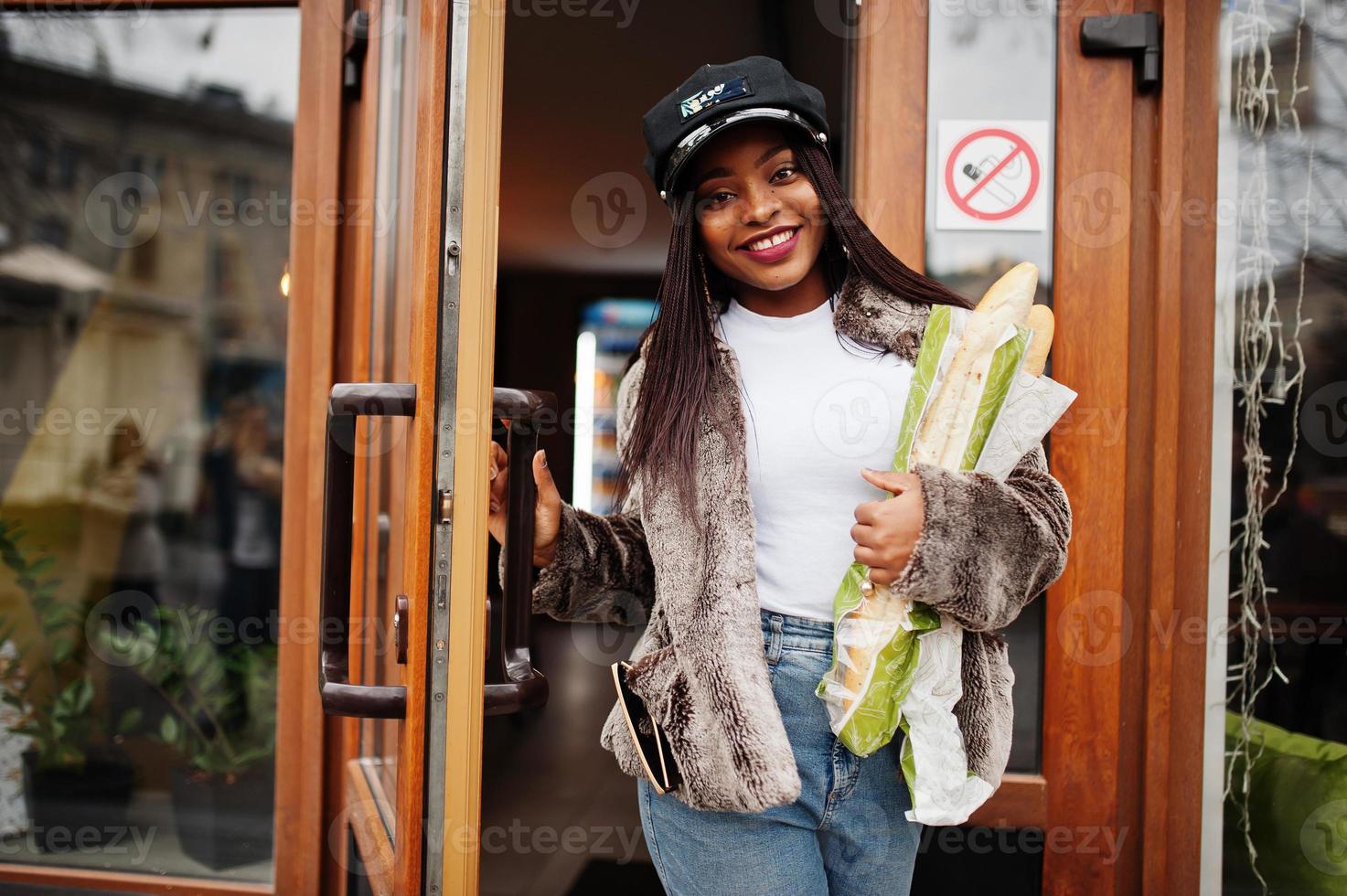 mujer afroamericana de moda con gorra negra y piel con dos rollos de  baguette en las manos. 10430062 Foto de stock en Vecteezy