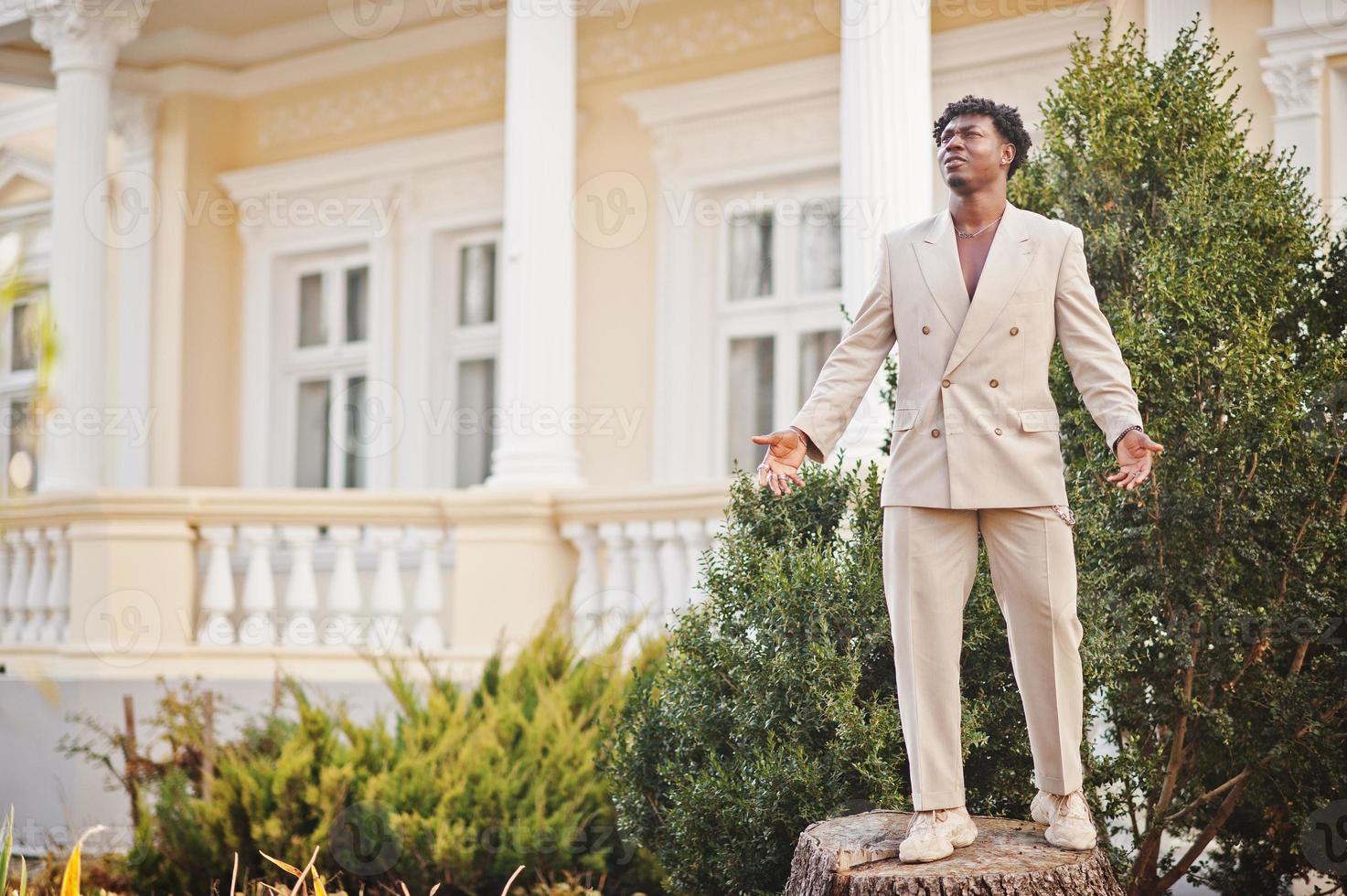 Stylish afro man in beige old school suit. Fashionable young African male in casual jacket on bare torso. photo