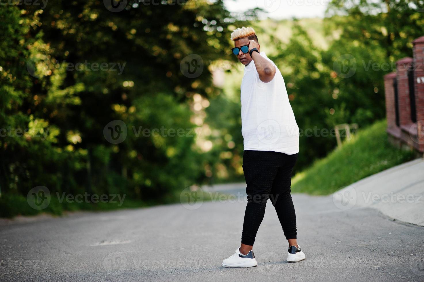 Stylish arabian muslim boy with originally hair and sunglasses posed on streets. photo