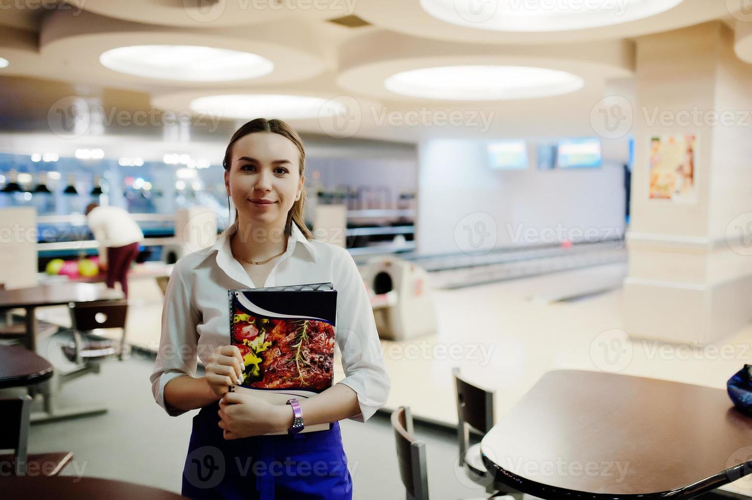 Waiter girl holding menu at cafe. People and service concept photo