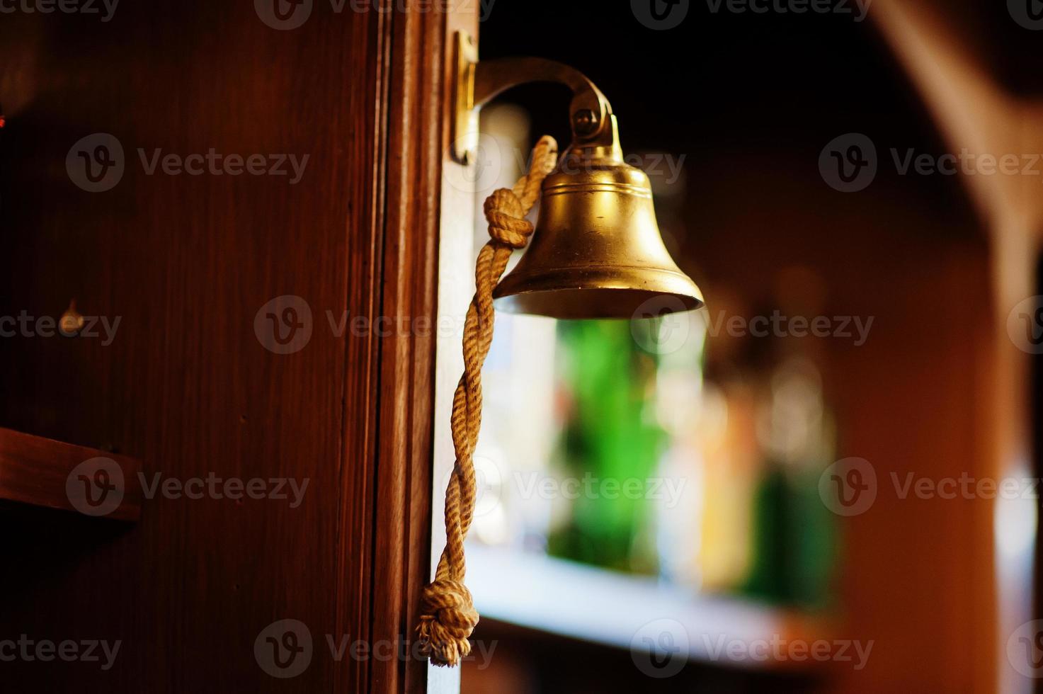 Old bell with woven rope in bar counter. photo