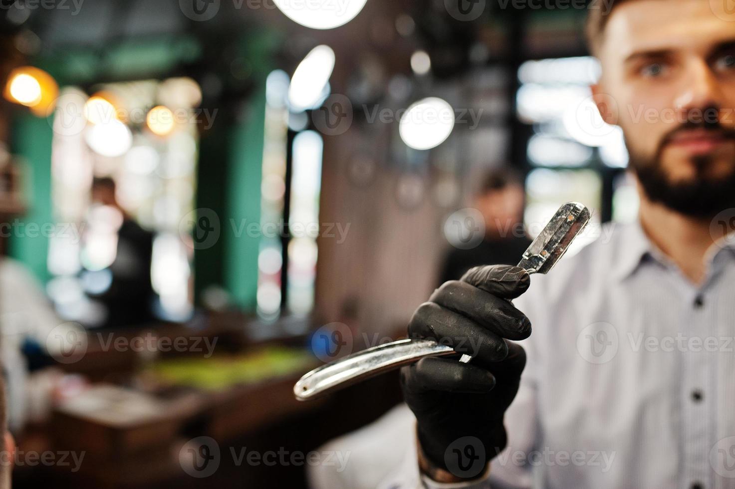Handsome bearded man at the barbershop, barber at work. photo