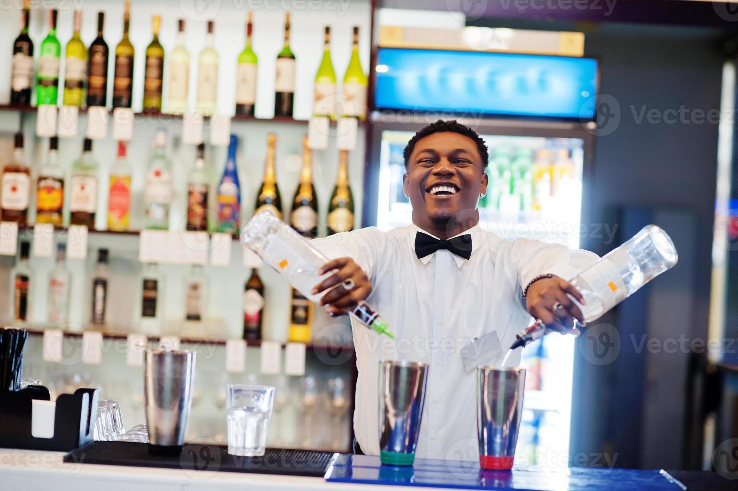 camarero afroamericano trabajando detrás del bar de cócteles. preparación de bebidas alcohólicas. foto