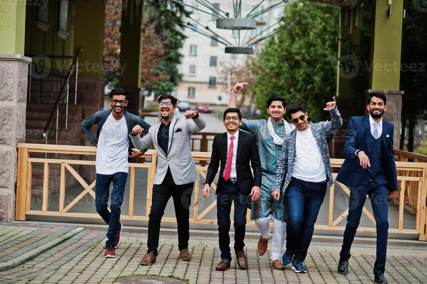 Group of six south asian indian mans in traditional, casual and business wear walking dancing and having fun together. photo