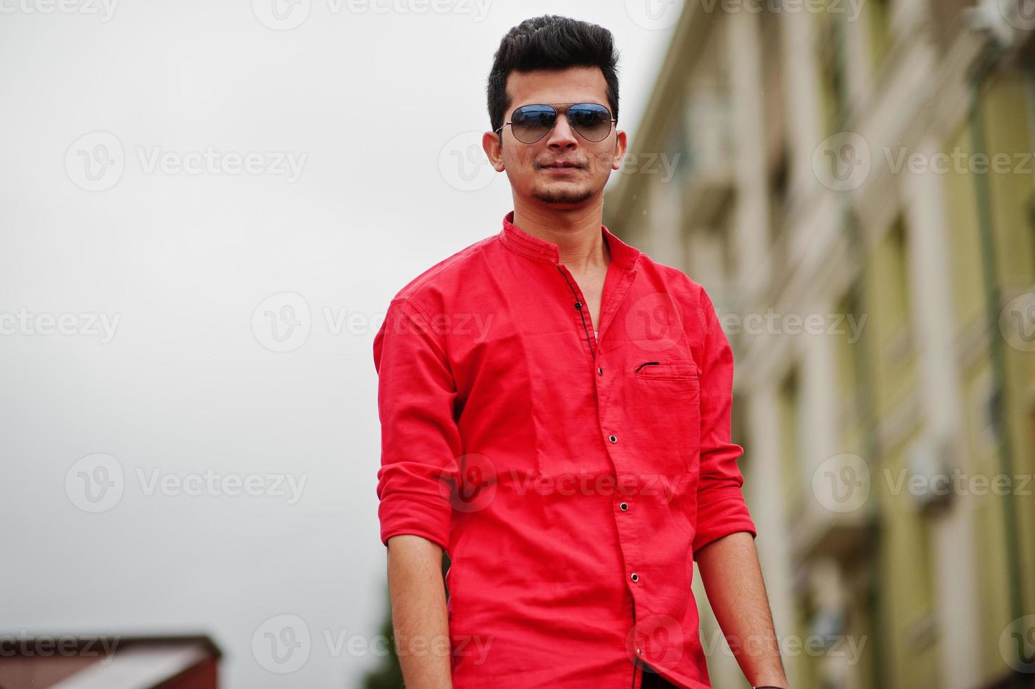 Indian man at red shirt and sunglasses posed outdoor. photo