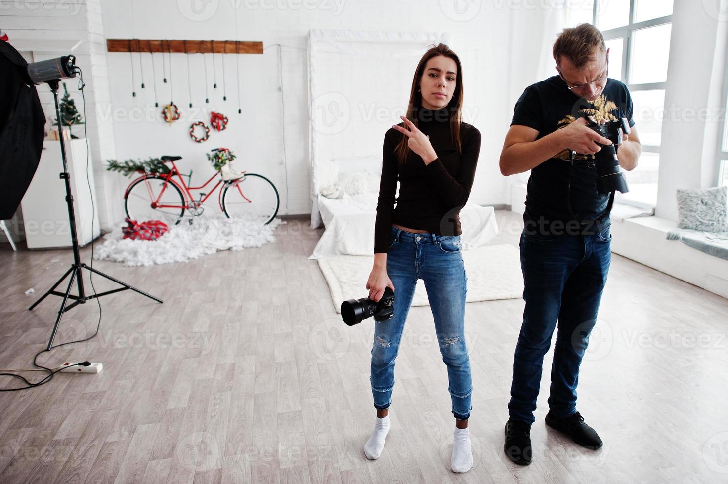 The team of two photographers looking at camera final work material on studio. photo