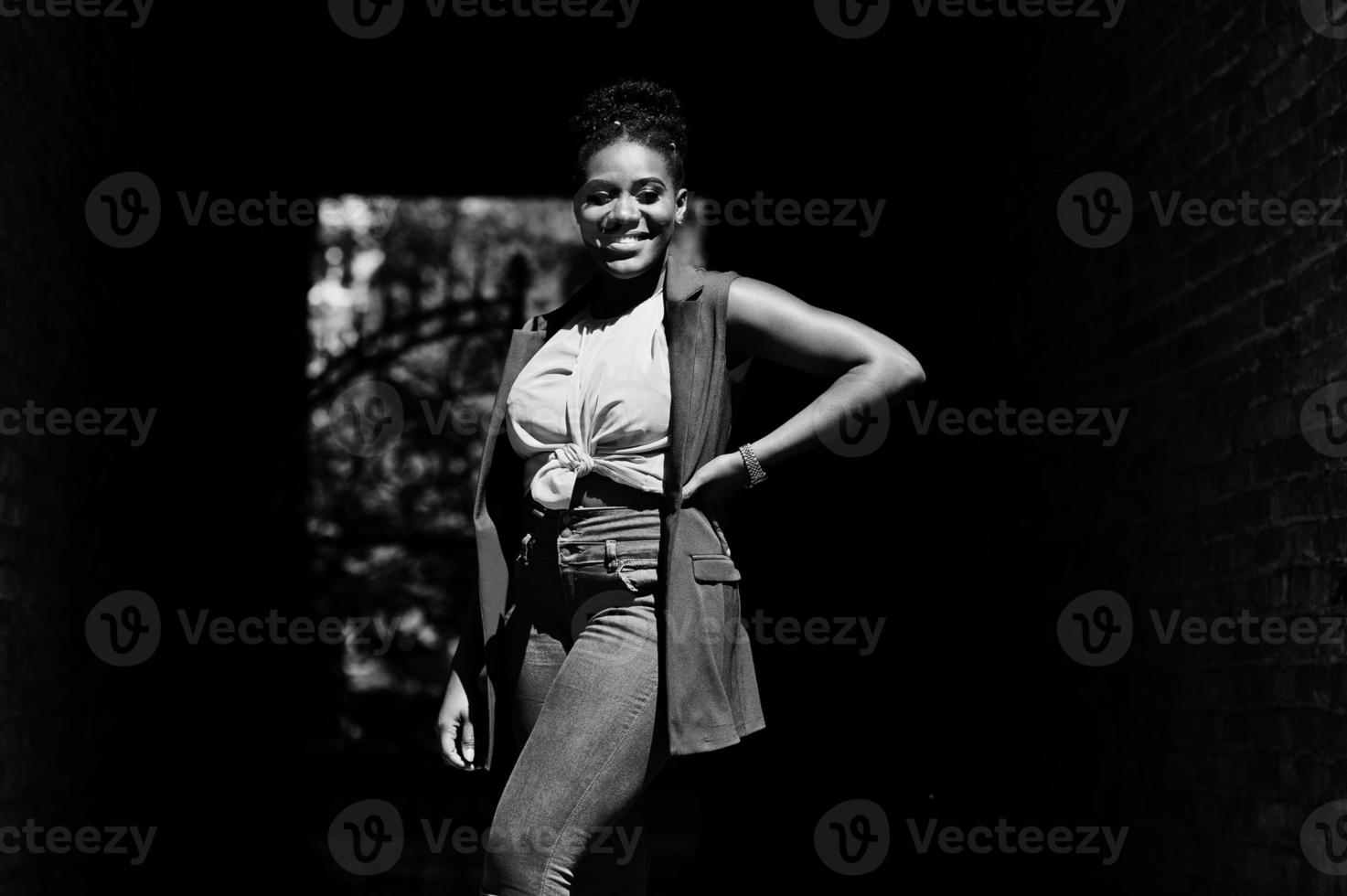 Stylish african american woman posed on tonnel arch at sunny day. photo