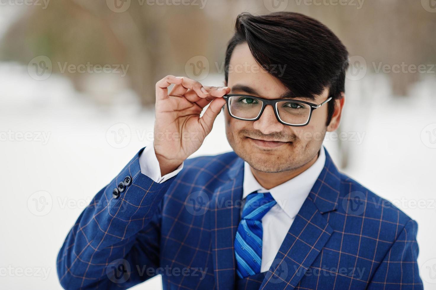 Close up portrait of stylish indian business man in suit and glasses posed at winter day outdoor. photo