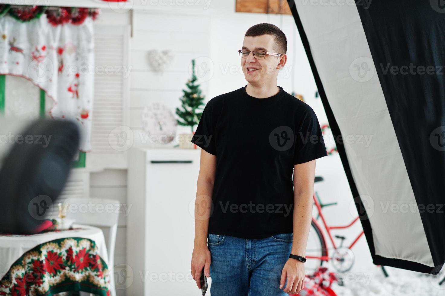 hombre de pie cerca de la luz del flash en el estudio. foto