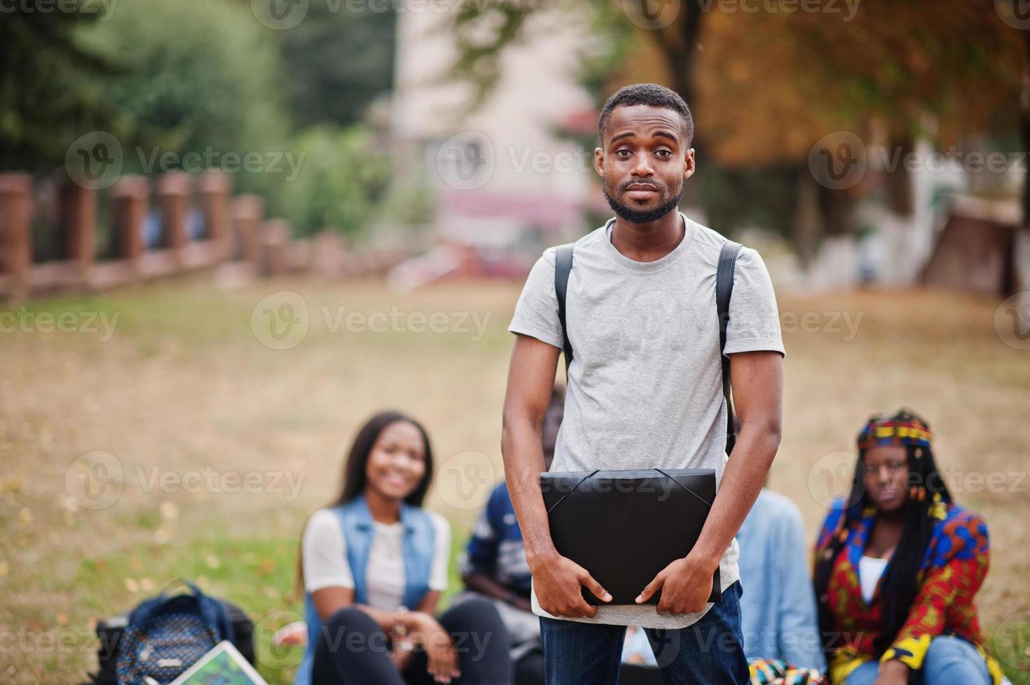 Group of five african college students spending time together on campus at university yard. Black afro friends studying. Education theme. photo