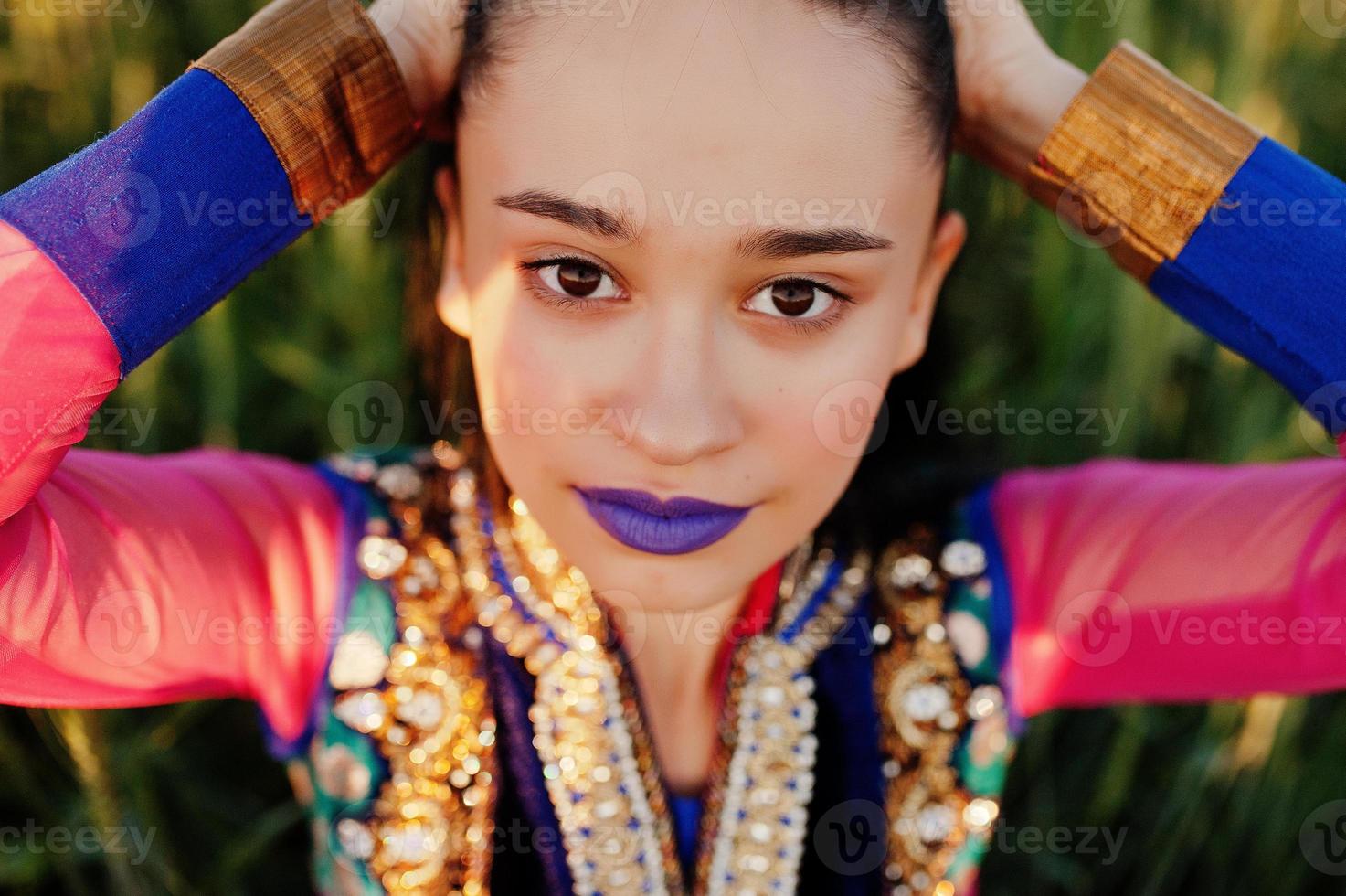 Tender indian girl in saree, with violet lips make up posed at field in sunset. Fashionable india model. photo