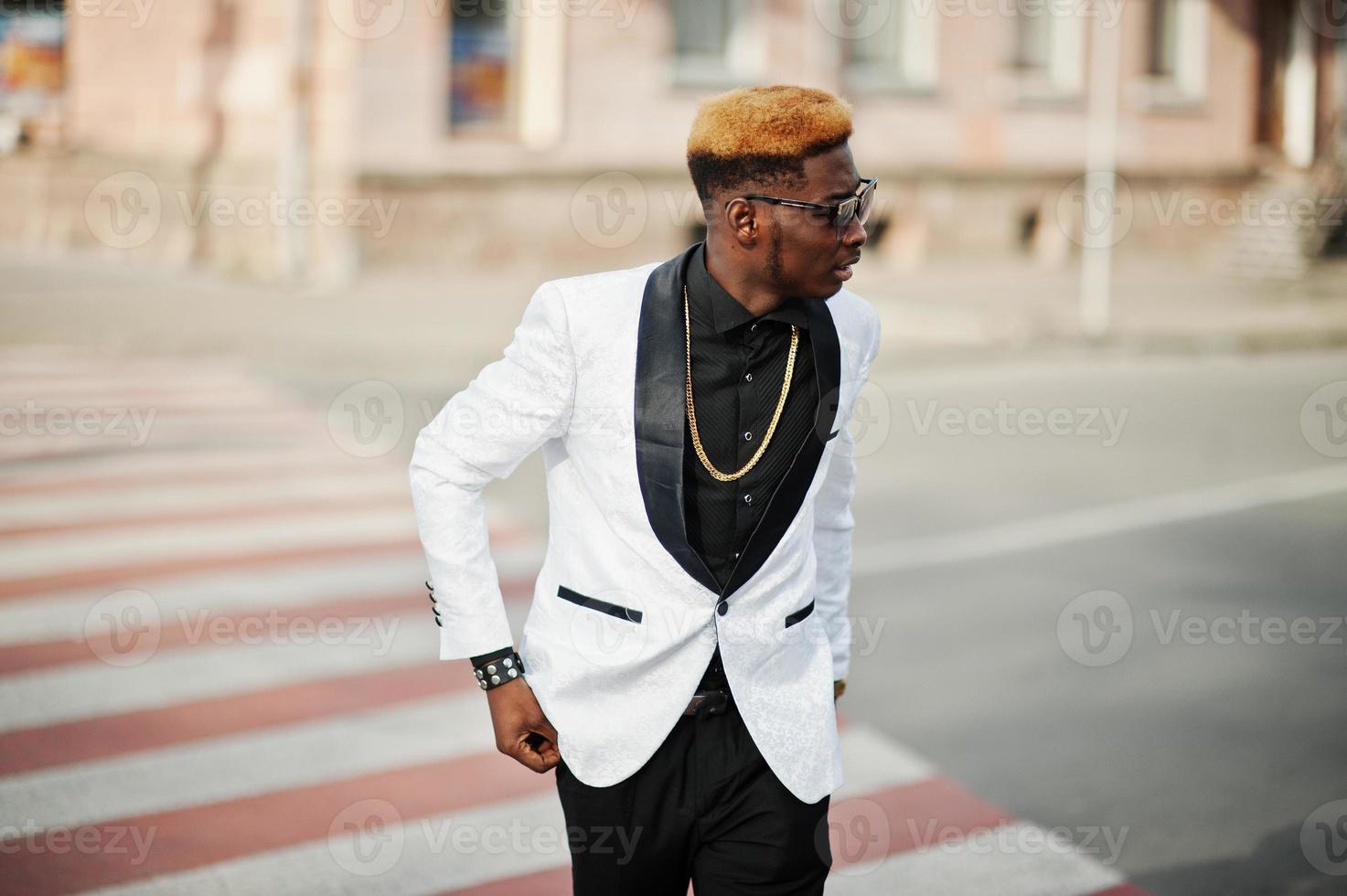 Chic handsome african american man in white suit walking on crosswalk. photo