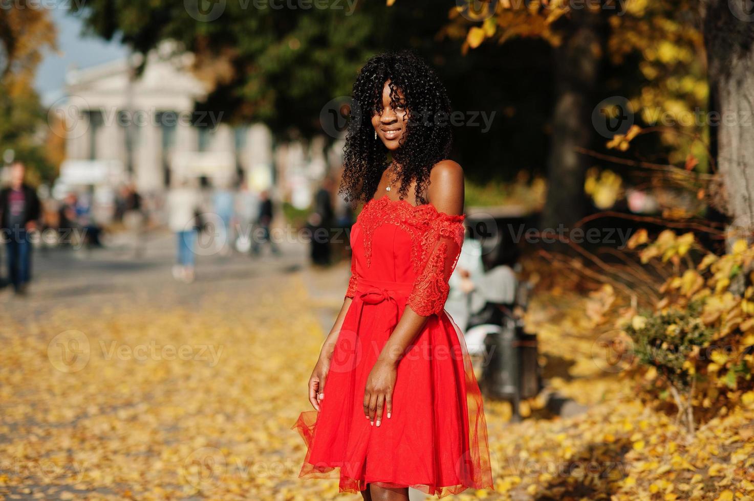 elegante mujer rizada afro francia de moda posó en el día de otoño con vestido rojo. modelo de mujer africana negra. foto