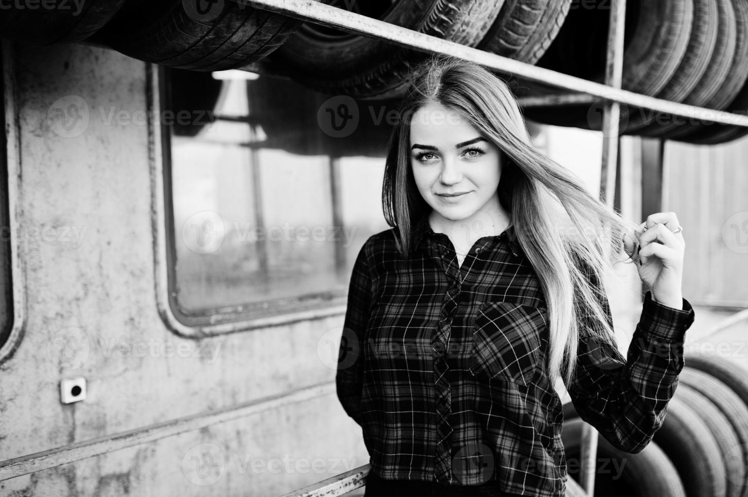 Young hipster girl in checkered shirt at tire fitting zone. photo