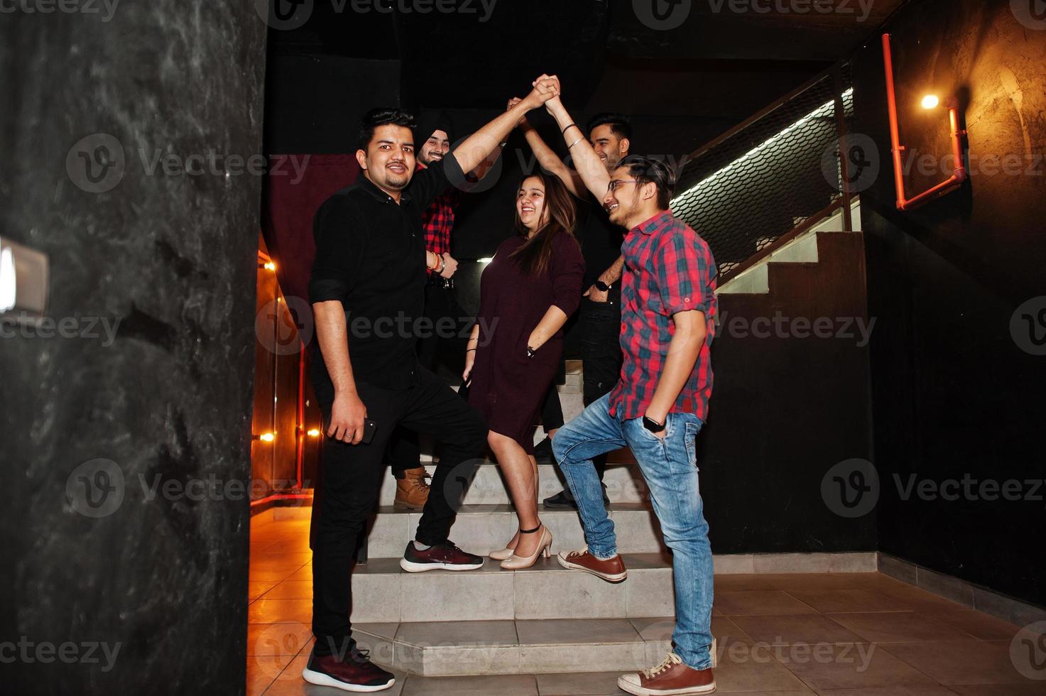 Group of indian friends having fun and rest at night club. photo