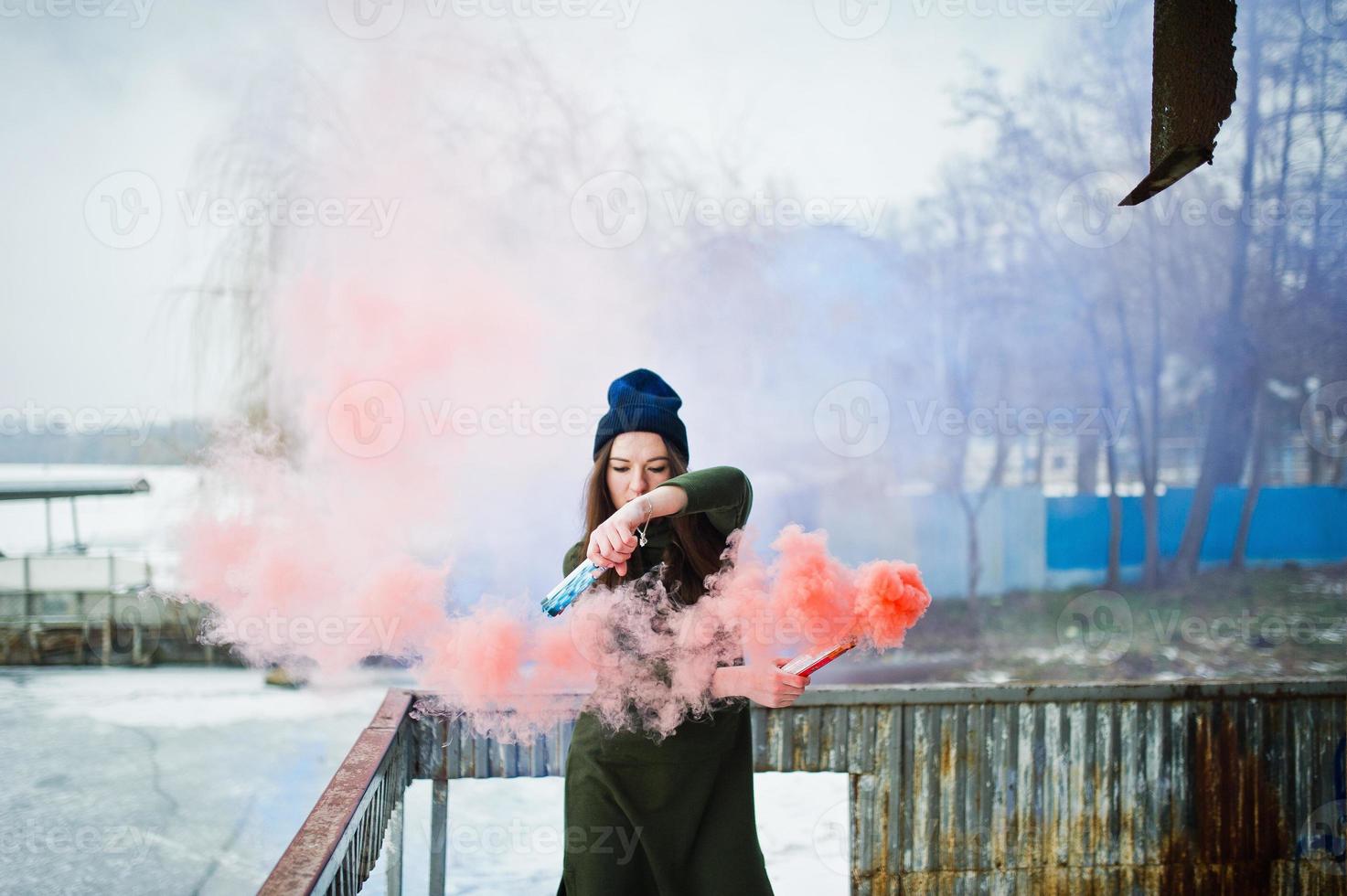 Young girl with blue and red colored smoke bomb in hands. photo