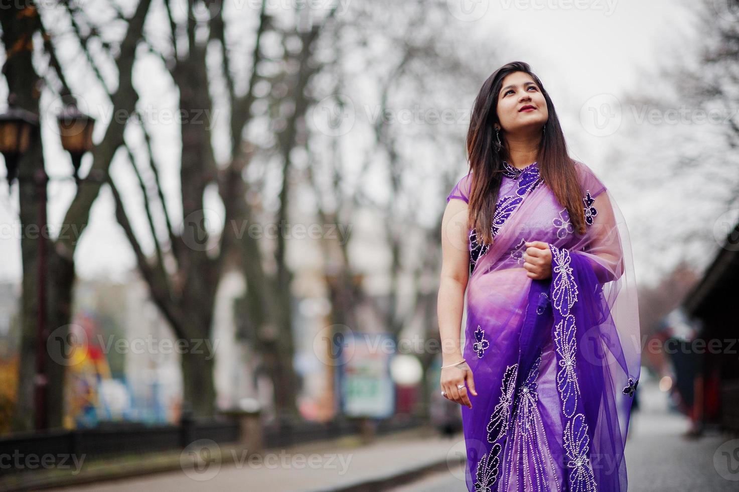 Indian hindu girl at traditional violet saree posed at street. photo