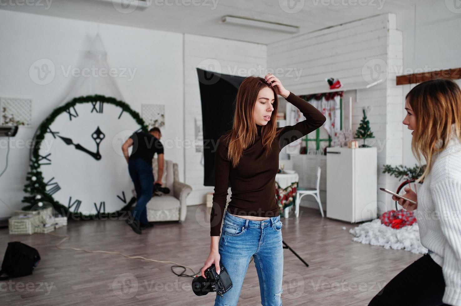 Young photographer girl discussing with anonther worker at studio. photo