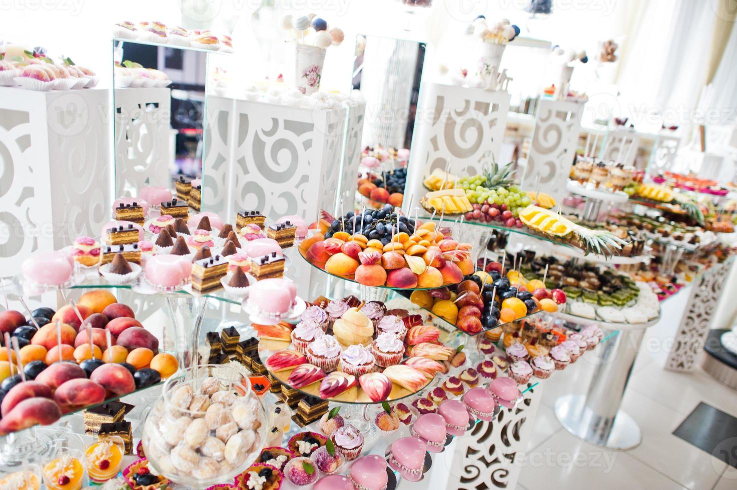 hermosa barra de dulces de boda con dulces, frutas y comida. mesa de banquete de boda foto