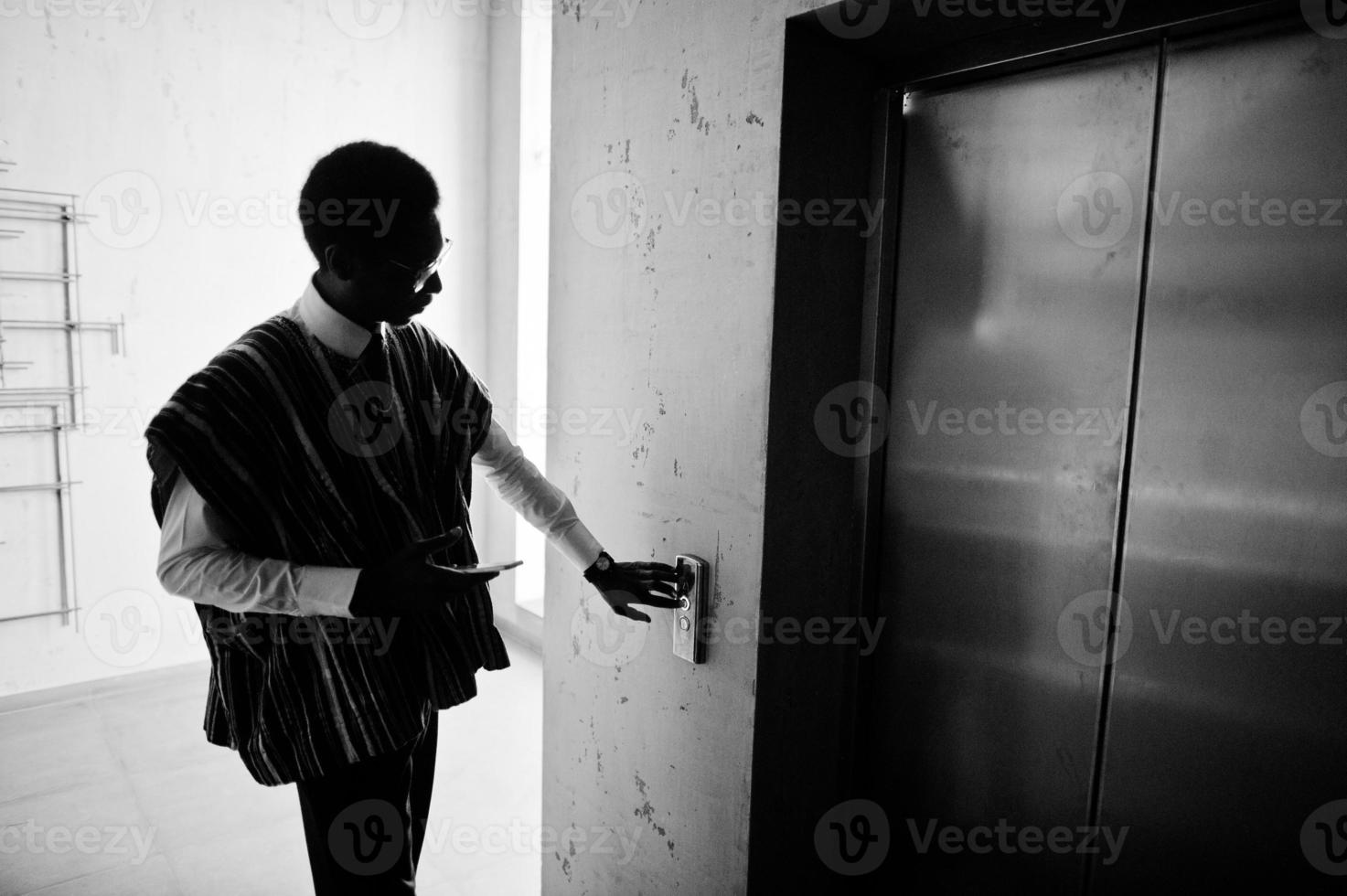 African american man at elavator or modern lift, pushing button. photo