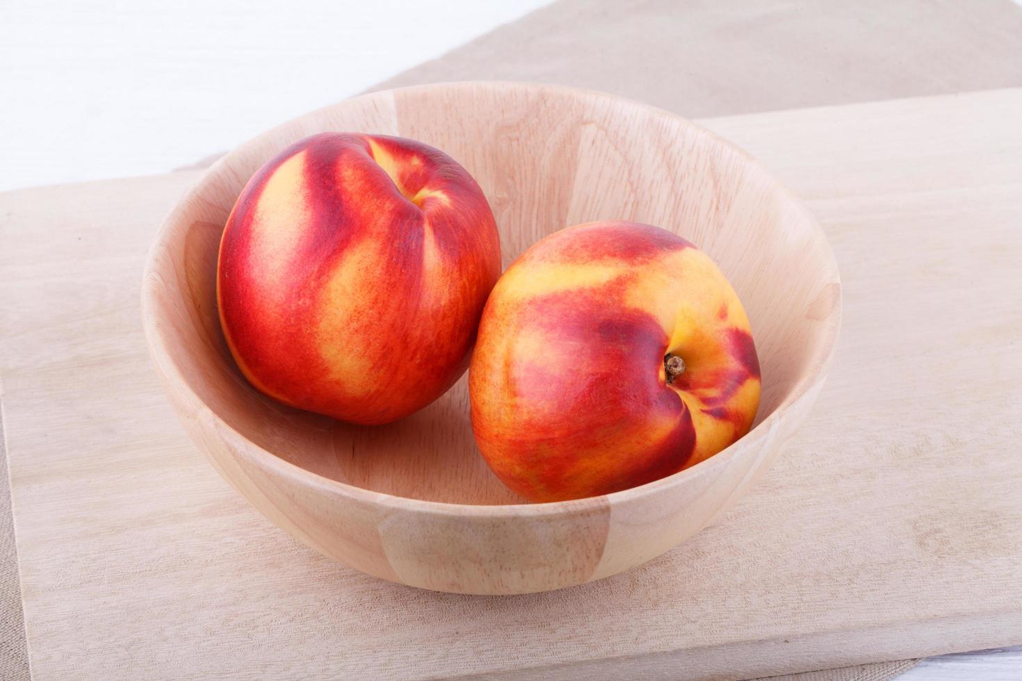 nectarines in bowl on wood table photo