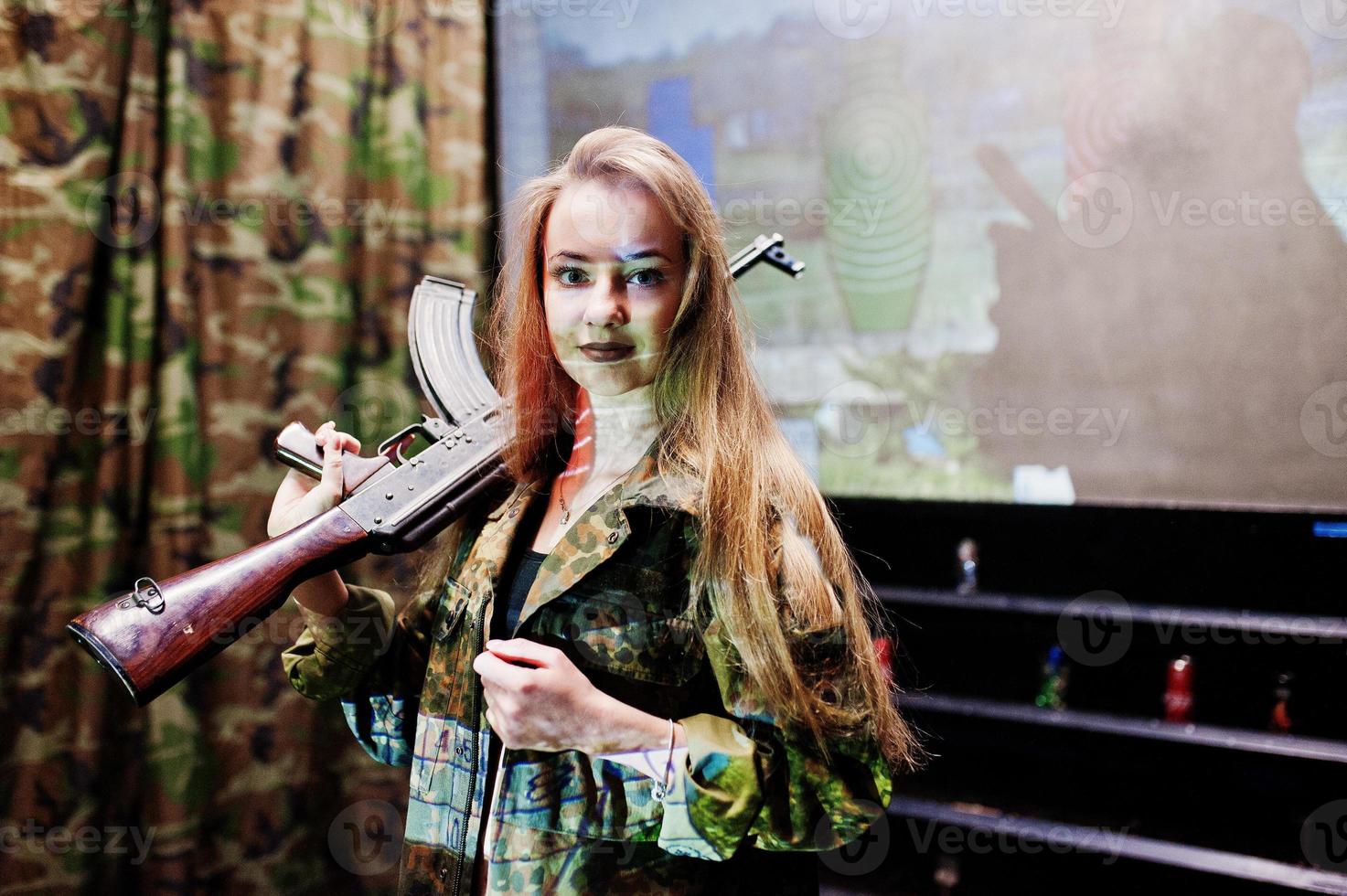 Girl with machine gun at hands on shooting range. photo