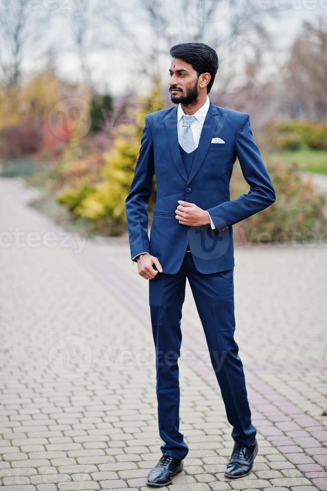 hombre indio de barba elegante con bindi en la frente, vestido con traje  azul posado al aire libre. 10437244 Foto de stock en Vecteezy