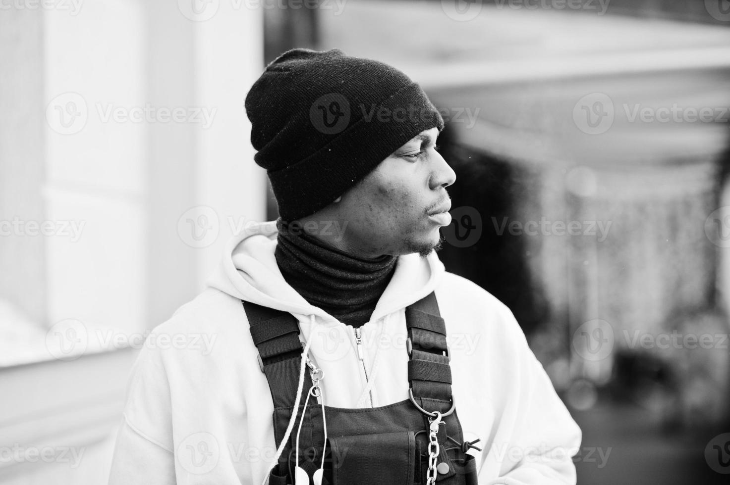 Close up head of stylish urban style african american man in pink hoodie and black hat posed. photo