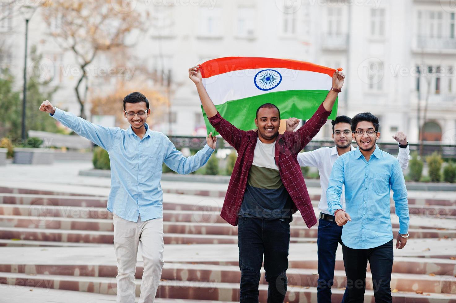 grupo de cuatro hombres indios del sur de asia con bandera india. foto