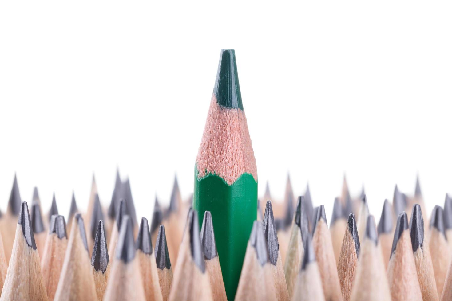 One sharpened green pencil among many ones photo