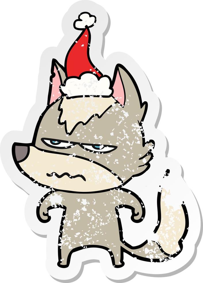 distressed sticker cartoon of a annoyed wolf wearing santa hat vector