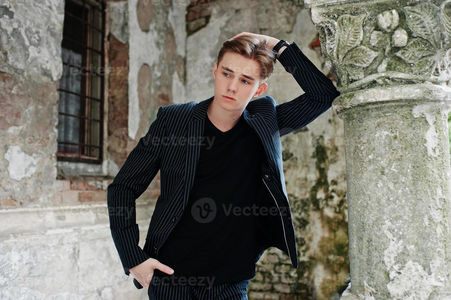 joven macho con estilo en chaqueta negra planteada al aire libre de la calle. increíble modelo de hombre. foto