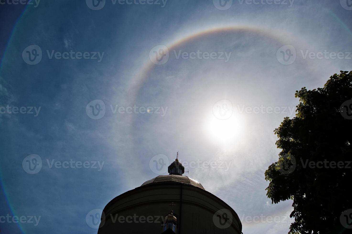 Fantastic beautiful sun halo phenomenon up the church, circular rainbow. photo