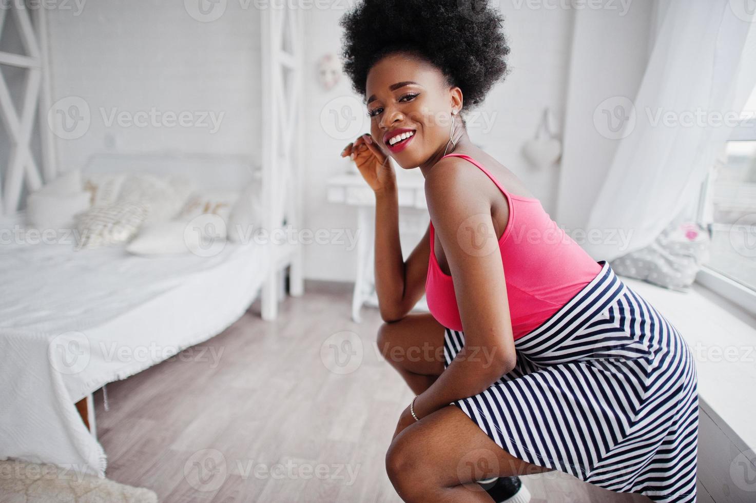 Attractive african american woman with afro hair wear on skirt pink top,  posed at white room. Fashionable sexy black model. 10439218 Stock Photo at  Vecteezy